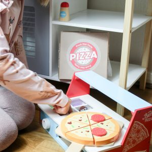 kid playing with wooden pizza base and wooden food/vegetables toy