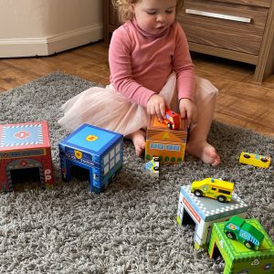 Little Girl Playing With Colourful Wooden Vehicle Toys